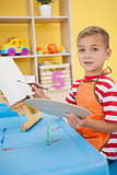 Cute little boy painting at table in classroom
