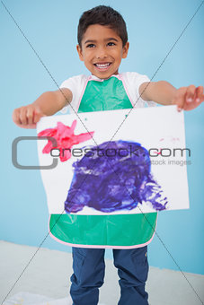 Cute little boy showing his painting in classroom