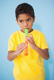 Cute little boy playing the recorder in classroom