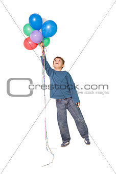 Happy little boy holding bunch of balloons