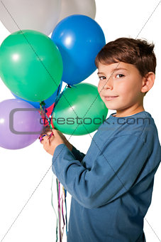 Happy little boy holding bunch of balloons