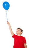 Happy little boy holding blue balloon