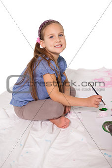 Happy little girl painting on the floor