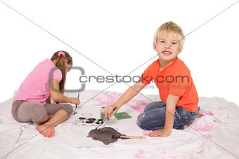 Happy little children painting on the floor