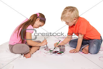 Happy little children painting on the floor