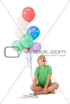 Happy little boy in tiger face paint with balloons