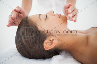 Beautiful brunette getting reiki therapy