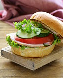 snack burger with fresh vegetables and ham on a wooden board
