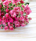bouquet of roses with gift box on a wooden background