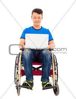 happy young man sitting on a wheelchair with a laptop