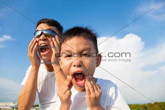father and son making a grimace together in the park