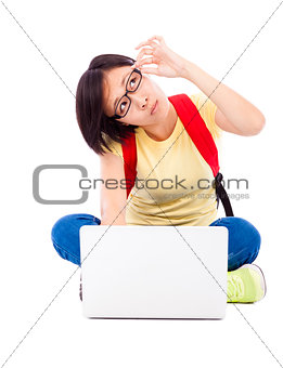 doubted young student girl sitting on floor with a laptop