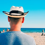 young man with a straw hat on the beach