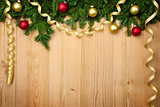 Christmas background with firtree, baubles and ribbons on wood