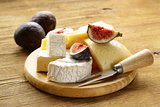 cheeseboard with maasdam, camembert, cheddar cheese and figs