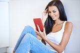 Smiling woman reading information on her tablet