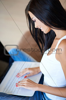 Young woman typing on a laptop computer