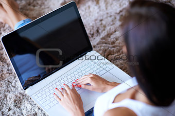 Hands of a woman typing on a laptop computer