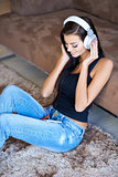 Woman relaxing on the floor listening to music