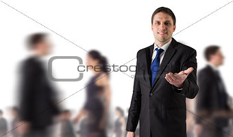 Composite image of handsome businessman holding hand out