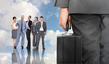 Composite image of businessman holding briefcase
