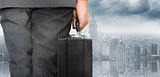 Composite image of businessman holding briefcase