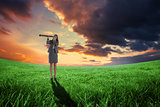 Composite image of businesswoman looking through a telescope