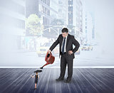 Composite image of mature businessman watering tiny businesswoman