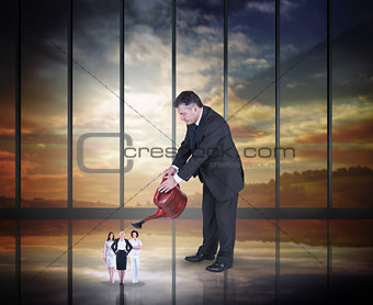 Composite image of mature businessman watering tiny business women