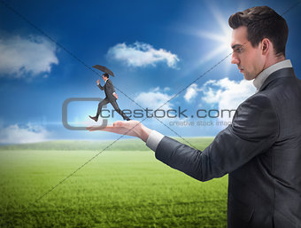 Composite image of businessman holding business man jumping