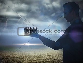 Composite image of businessman holding business team