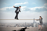 Young businesswoman pulling a tightrope for businessman