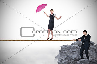 Young businessman pulling a tightrope for businesswoman