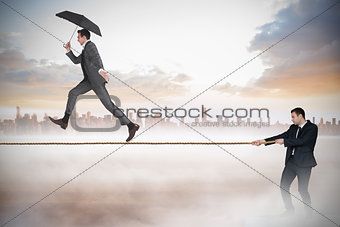 Young businessman pulling a tightrope for business man