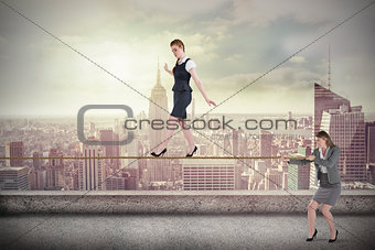 Young businesswoman pulling a tightrope for business woman