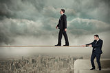 Young business man pulling a tightrope for businessman