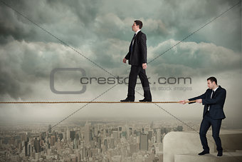 Young business man pulling a tightrope for businessman