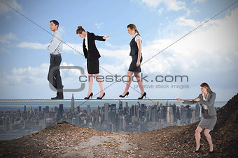 Young businesswoman pulling a tightrope for business people