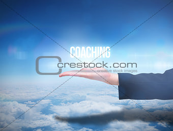Businesswomans hand presenting the word coaching