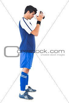 Football player in blue with ball