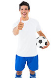 Football player in white holding ball showing thumbs up