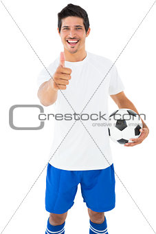 Football player in white holding ball showing thumbs up