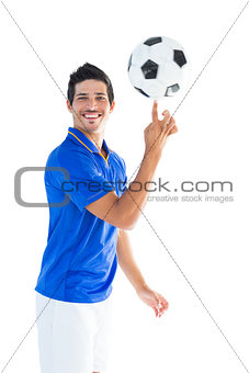 Football player in blue spinning ball
