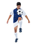 Football player in blue kicking ball