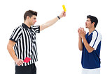 Referee showing yellow card to football player
