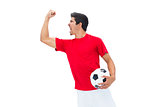 Football player in red holding ball and cheering
