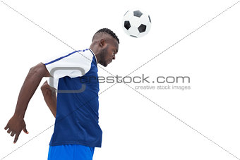Football player in blue heading ball