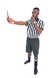 Serious referee showing red card blowing whistle