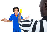 Serious referee showing yellow card to player