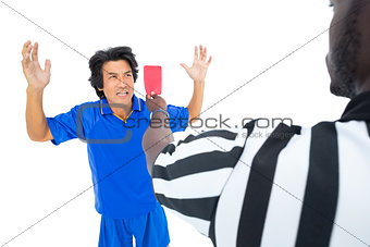 Serious referee showing red card to player